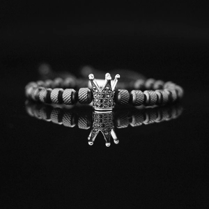 Close-up of vintage titanium steel crown charm bracelet with black stones and knurled beads