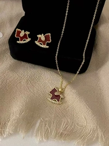 Detail view of 18K gold plated horse jewelry set with red enamel and zircons in a box