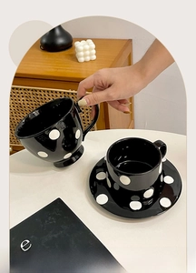 Tasse à café en céramique à pois avec soucoupe assortie dans un décor vintage