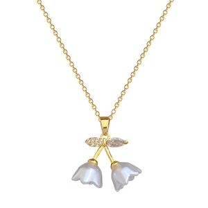Elegant gold cherry pendant necklace featuring white pearls and sparkling rhinestones