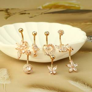 Detail showing a collection of gold belly rings with flower and butterfly zircon designs