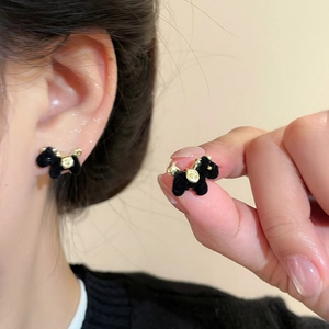 Close-up of elegant black flocked Scottish Terrier earrings with golden details