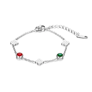 Close-up of stainless steel bracelet with red and green clover motifs and gems