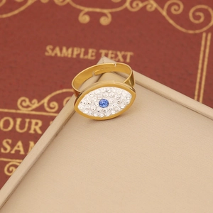 Gold evil eye jewelry set with blue main stone and crystal pavé on a beige gift box