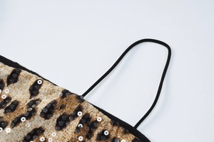 Detailed macro view of leopard print fabric with sequins and a thin black strap