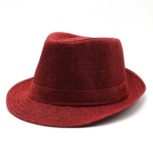 Gros plan sur la texture tissée rouge foncé d'un chapeau fedora en lin respirant et chic