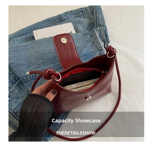 Detail of burgundy crossbody bag interior with zipper compartment and magnetic closure