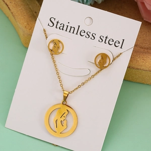 Detail of gold stainless steel necklace and earrings set featuring a prayer figure pendant