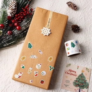 Detailed view of Christmas stickers on a gift box with pine branches and berries
