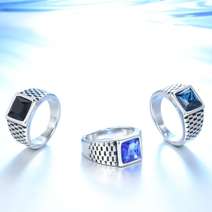 Detailed view of silver men's rings with square black and blue gemstones in a stack