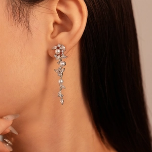 Detail of silver drop earrings with zircons and pearls showing elegant tassel drape
