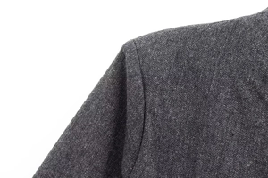 Nahaufnahme der dunkelgrauen Tweed-Jacke mit Fokus auf Schulternaht und feine Texturqualität