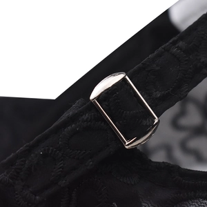 Detailed close-up of intricate black lace embroidery with a silver metal buckle