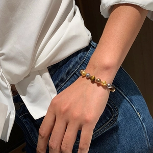 Bracelet magnétique vintage en œil de tigre et perles pour femme porté au poignet