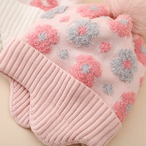 Pink winter knit hat for girls with fuzzy flower patterns and soft pompom ear flaps