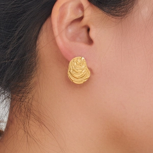 Detailed view of 18K gold hammered lava texture stud earring worn on model ear