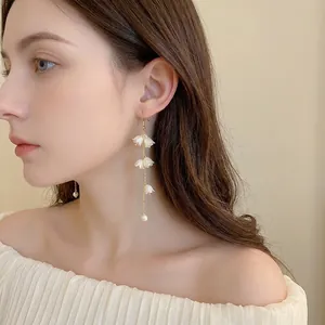Boucles d'oreilles élégantes en muguet acrylique et perles en vue latérale sur mannequin