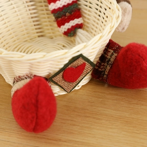 Christmas plush character woven candy basket decoration on a rustic wooden table