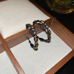 Detail view of vintage hoop earrings with tiger eye stones and sparkling rhinestones