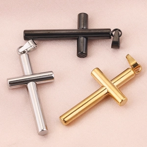 Detailed view of cross pendants in black, silver, and gold finish on silk fabric
