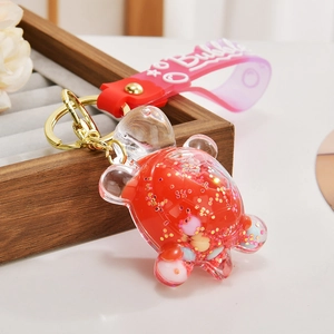 Macro view of a clear turtle keychain with red liquid and colorful sequins