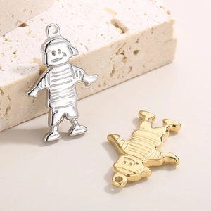 Hip hop style metal cartoon boy pendants in gold and silver finish on stone background