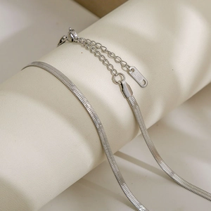 Detail of silver stainless steel flat snake chain with lobster clasp and S.STEEL tag