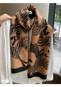 Close-up of bohemian zebra pattern shawl with soft beige tassels and fabric texture