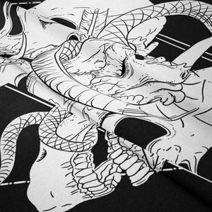 Detailed view of black and white gothic tapestry fabric with skull and scales print