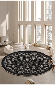 Detail view of large round black rug with beige floral pattern in a modern living room