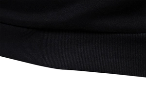 Detailed close-up of ribbed hem on men's black knit sweatshirt showing fabric texture