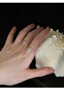 Detailed close-up of 925 sterling silver heart ring with a delicate pearl pendant charm