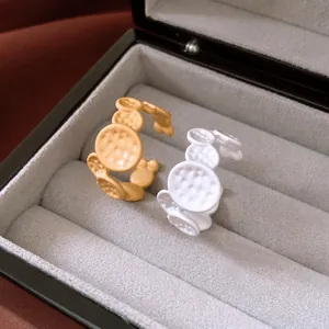 Pair of gold and white textured oval open rings featuring chic matte enamel finishes