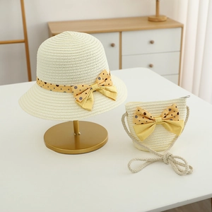 Detail of kids straw hat and matching crossbody bag set with yellow polka dot bow decorations