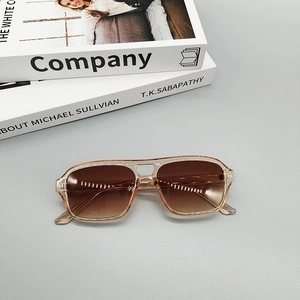 Detalle de gafas de sol aviador transparentes champán con lentes degradadas marrones