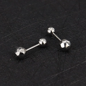 Detailed macro shot of 16g stainless steel barbell studs with faceted silver ends
