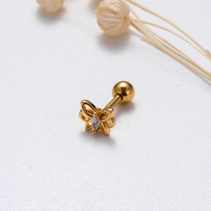 Golden butterfly stud earring with cubic zirconia on minimalist floral background