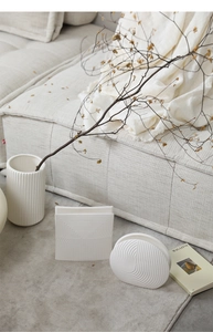Three white ceramic geometric vases in a modern minimalist home setting with dry branches