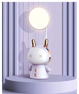 Close-up of purple rabbit character LED desk lamp with gold ears and warm round light