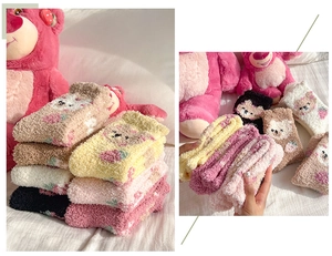 Close-up of cozy coral fleece socks with cute cartoon bear and strawberry patterns