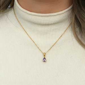 Détail du collier avec pendentif zircon violet plaqué or 18K sur un pull blanc