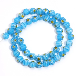 Close-up of sky blue Millefiori glass beads with white stripes and floral patterns