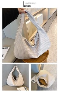 Macro detail of creamy white woven leather tote bag showing texture and zipper closure