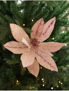 Close-up of champagne pink velvet poinsettia with glitter on green Christmas tree