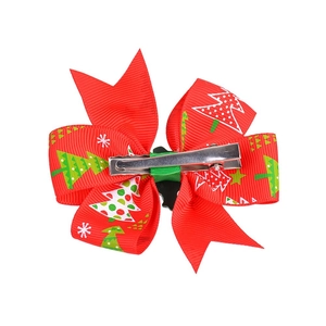 Christmas hair clip with red ribbon bow featuring festive Xmas tree and snowflake patterns