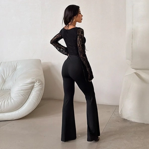 Vue détaillée du combi-pantalon noir slim avec manches en dentelle et jambes évasées