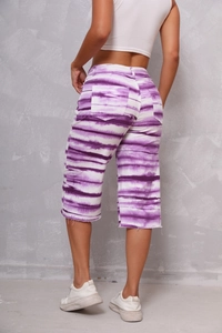 Rear view of purple tie-dye wide-leg denim shorts with raw hem and back pockets