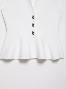 Detailed view of white knitted vest featuring unique irregular silver metal buttons