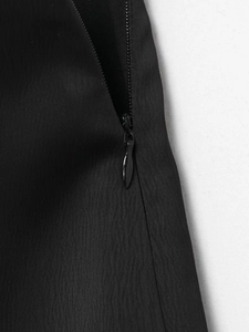 Détail de la fermeture éclair invisible et du tissu tissé noir de la jupe-culotte