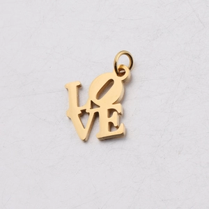 Detail of a gold stainless steel Love charm with a smooth finish and hanging ring